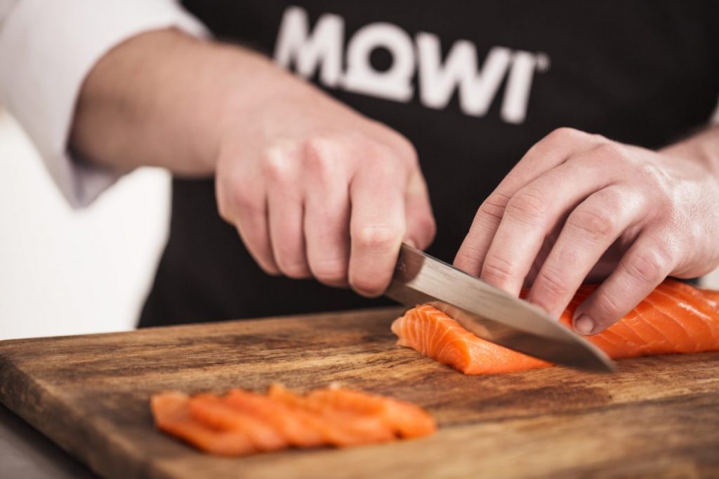 chef taglia filetto di salmone fresco